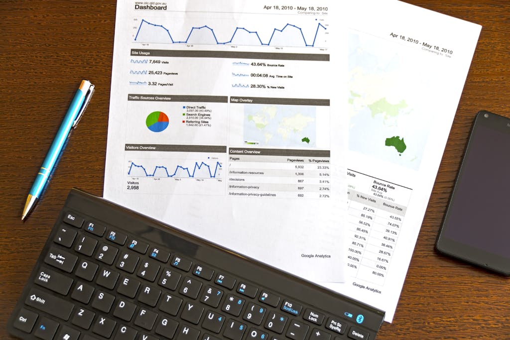 flatlay of a business analytics report keyboard pen and smartphone on a wooden desk. 95916