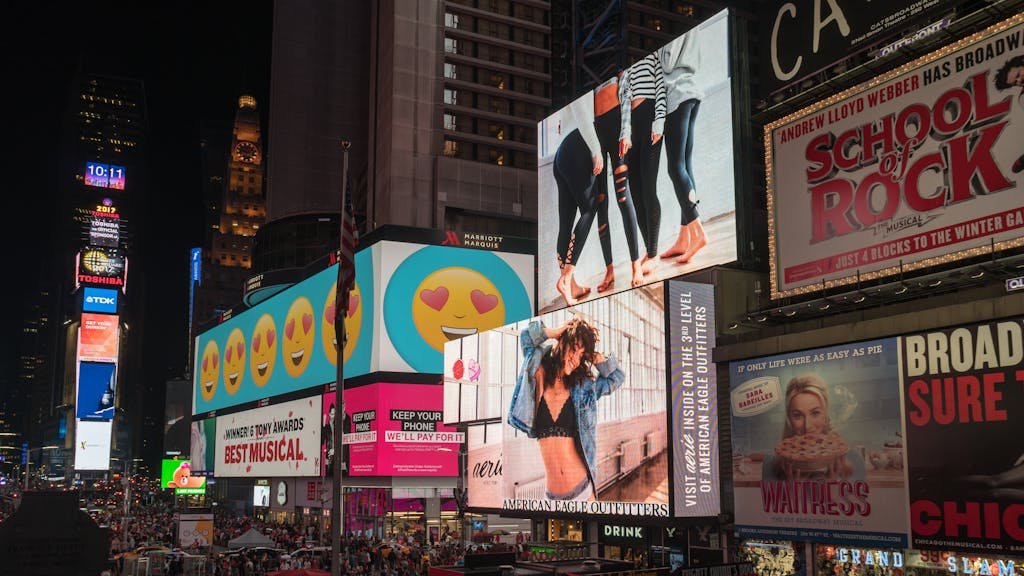 Como o marketing pode impulsionar projetos de infraestrutura urbana 7 Colorful billboards light up New York City's iconic Times Square at night, with vibrant ads and bustling crowds.