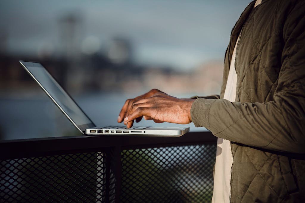 Como o marketing pode impulsionar projetos de infraestrutura urbana 5 Man working on a laptop outdoors with city skyline background.